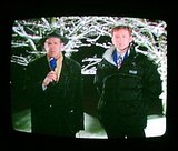 Beeldvergroting: Presentator en weerman laten in het Journaal zien dat het buiten heeft gesneeuwd.