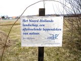 Beeldvergroting: Foto 3. Nieuw! Op een in het landschap geplaatst bord kunnen we lezen wat we zien. Het kortste verhaal dat Jan Wolkers ooit schreef.